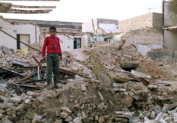 Иранский мальчик на руинах своего дома в Ахвазе, разрушенного воздушным налетом в ходе ирано-иракской войны. 25 января 1987 года - Sputnik Moldova-România