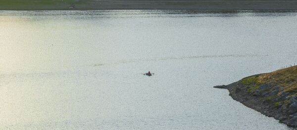 Человек в лодке на водохранилище Костешты-Стынка у села Вэратик Человек в лодке на водохранилище Костешты-Стынка у села Вэратик - Sputnik Молдова