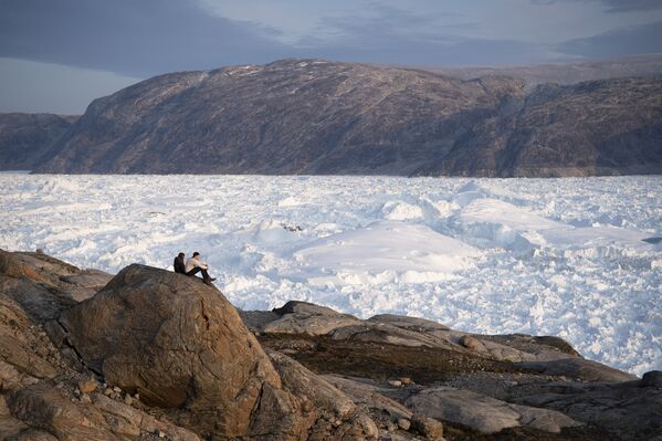 Студенты нью-йоркского университета сидят на скале с видом на ледник Хельхейм в Гренландии - Sputnik Moldova-România