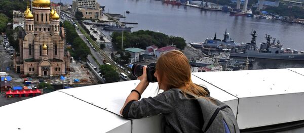 Девушка фотографирует с крыши высотного здания администрации Приморского края во Владивостоке - Sputnik Moldova-România