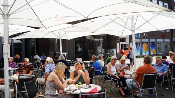 Посетители летнего кафе на одной из улиц города Любек - Sputnik Moldova