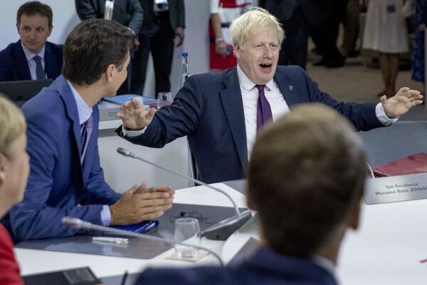 Premierul Marii Britanii, Boris Johnson(dreapta) vorbește, flancat de premierul canadian, Justin Trudeau (stânga), în timpul unei sesiuni de lucru privind „Economia internațională și comerțul și agenda de securitate internațională” la Biarritz, sud-vestul Franței, pe 25 august 2019, în a doua zi a Summit-ului anual al G7, la care au participat liderii celor șapte democrații cele mai bogate din lume, Marea Britanie, Canada, Franța, Germania, Italia, Japonia și Statele Unite. - Sputnik Moldova-România