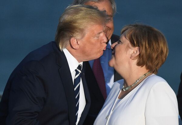 Președintele SUA, Donald Trump, o sărută pe cancelarul german Angela Merkel în timpul unei sesiuni de fotografie de familie la summitul G7 de la Biarritz, Franța, 25 august 2019. - Sputnik Moldova-România