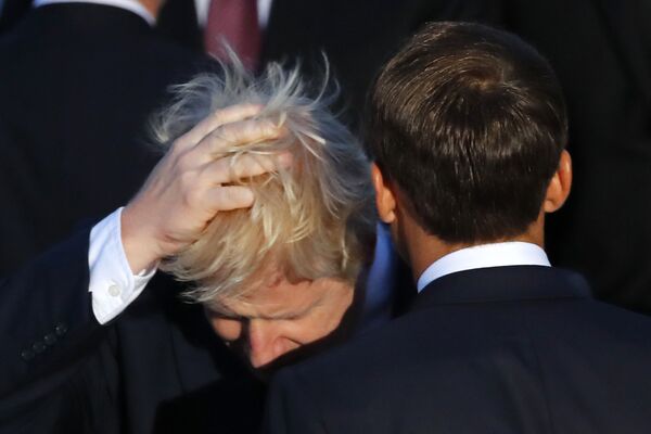Premierul britanic Boris Johnson își atinge părul, fiind alături de președintele francez Emmanuel Macron în timpul fotografiei de familiei la G7, duminică, 25 august 2019, la Biarritz.  - Sputnik Moldova-România