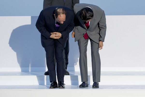 Președintele egiptean Abdel Fattah el-Sisi, în stânga, și premierul japonez Shinzo Abe, în dreapta, își caută numele în momentul în care ajung pentru sesiunea de fotografiere a grupului G7 la Hotel du Palais din Biarritz, Franța, duminică, 25 august 2019. - Sputnik Moldova-România