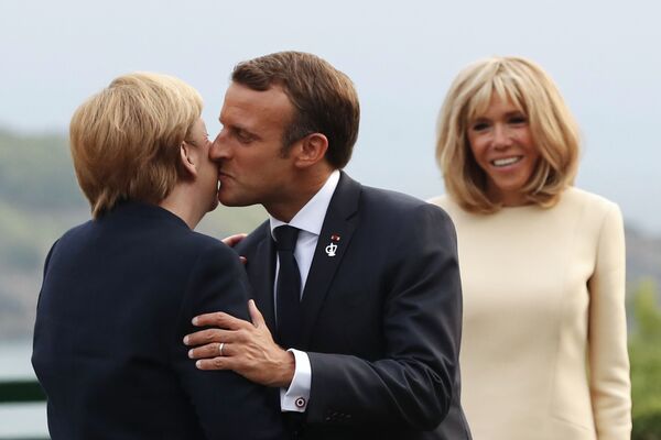 Președintele francez, Emmanuel Macron, o salută pe Angela Merkel, cancelarul german, cu un sărut, având-o în spate pe soția sa, Brigitte Macron, la farul Biarritz, sud-vestul Franței, înainte de o cină de lucru pe 24 august 2019, în prima zi a Summit-ului anual al G7 la care a participat liderii celor șapte democrații cele mai bogate din lume, Marea Britanie, Canada, Franța, Germania, Italia, Japonia și Statele Unite. - Sputnik Moldova