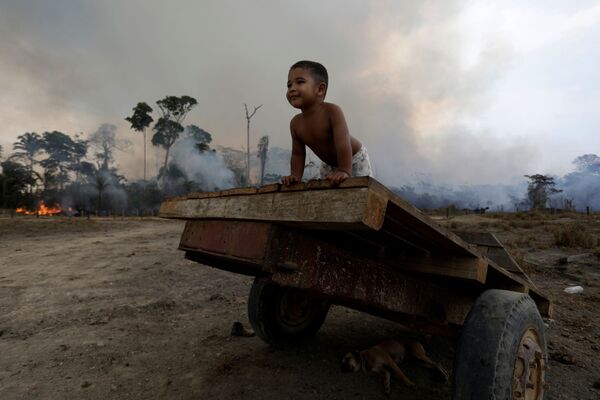 Ребенок играет во время природного пожара в лесах Амазонии  - Sputnik Moldova-România
