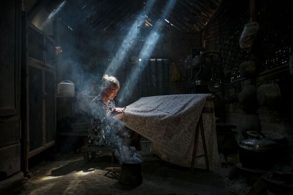 Снимок Under the light making batik crafts индонезийского фотографа Bimo Pradityo, представленный на фотоконкурсе AGORA Awards 2019 - Sputnik Молдова