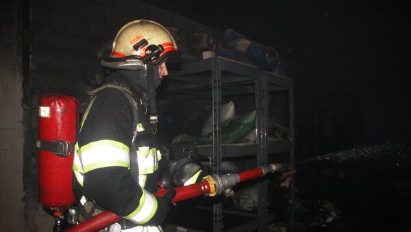 Пожарный во время тушения возгорания на автосервисе в Кишиневе - Sputnik Молдова