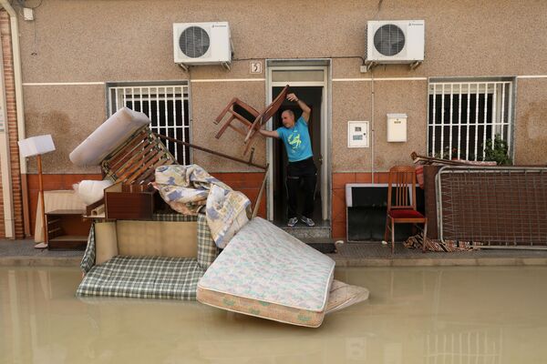 Мужчина выбрасывает мебель, испорченную в результате подтопления от проливных дождей, Альморади, Испания - Sputnik Молдова