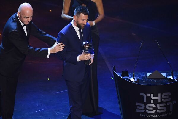 Jucător de fotbal Lionel Messi, ținând trofeul, la ceremonia de premiere FIFA din Italia - Sputnik Moldova-România