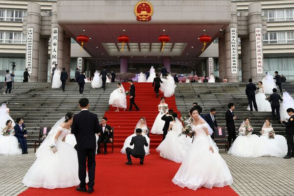 Молодожены на массовой свадьбе у здания городского правительства в преддверии 70-летия КНР - Sputnik Молдова