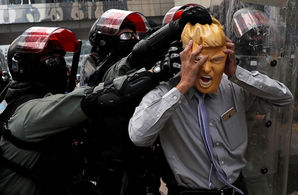 Антиправительственный демонстрант в маске президента США Дональда Трампа во время демонстраций в Гонконге - Sputnik Молдова