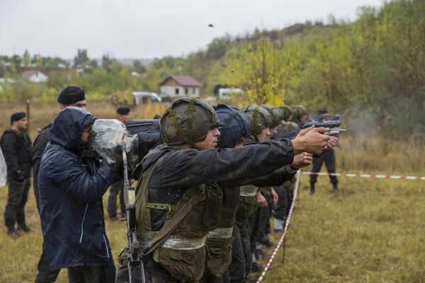 Participanții efectuează trageri practice din arma de foc. - Sputnik Moldova