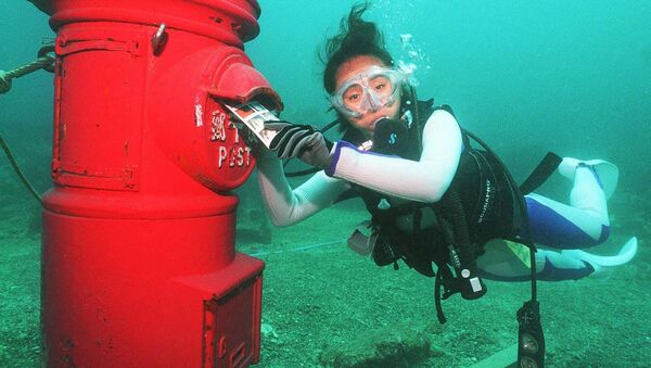 Водолаз кладет пластиковое письмо в почтовый ящик, установленный на глубине 10 метров на дне моря у берегов Сузами в префектуре Вакаяма. - Sputnik Молдова