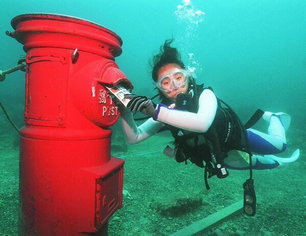 Водолаз кладет пластиковое письмо в почтовый ящик, установленный на глубине 10 метров на дне моря у берегов Сузами в префектуре Вакаяма - Sputnik Молдова