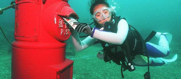 Водолаз кладет пластиковое письмо в почтовый ящик, установленный на глубине 10 метров на дне моря у берегов Сузами в префектуре Вакаяма - Sputnik Moldova-România