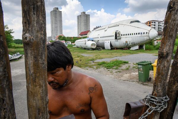Мужчина у ворот перед брошенным самолетом в пригороде Бангкока - Sputnik Молдова
