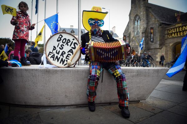 Демонстрант в костюме играет на аккордеоне, ожидая участия в марше за независимость Шотландии в Эдинбурге - Sputnik Молдова