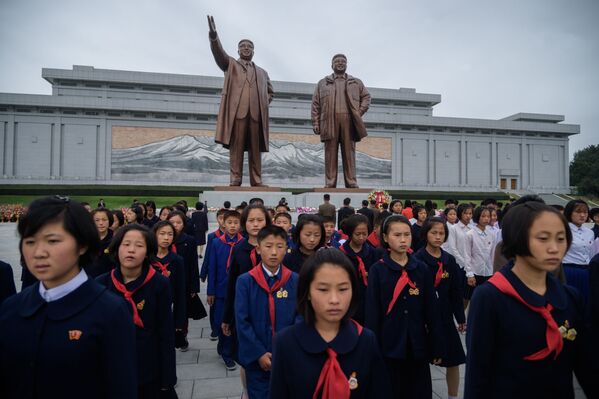 Студенты у статуй северокорейских лидеров Ким Ир Сена и Ким Чен Ира выражают свое почтение по случаю 74-й годовщины основания Рабочей партии Кореи, КНДР - Sputnik Молдова