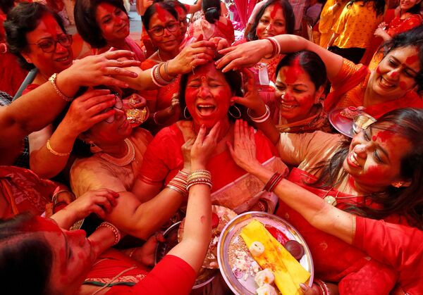 Нанесение цветного порошка на лицо индийской женщины в честь поклонения индуистской богине Дурги на фестивале Durga Puja в Чандигархе, Индия - Sputnik Молдова