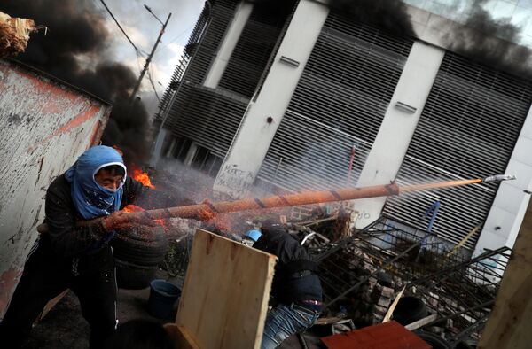 Демонстрант стреляет из самодельного оружия во время протеста в Кито, Эквадор - Sputnik Молдова