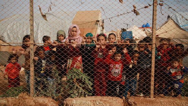 Сирийские дети у забора палаточного лагеря недалеко от деревни Кафр-Лусин, Сирия - Sputnik Молдова