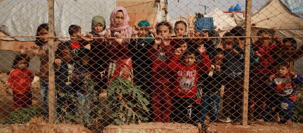 Сирийские дети у забора палаточного лагеря недалеко от деревни Кафр-Лусин, Сирия - Sputnik Молдова