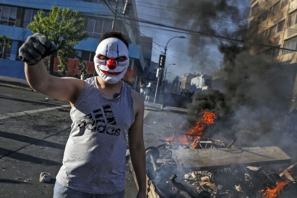 Демонстрант в маске во время протестов в Сантьяго, Чили - Sputnik Молдова