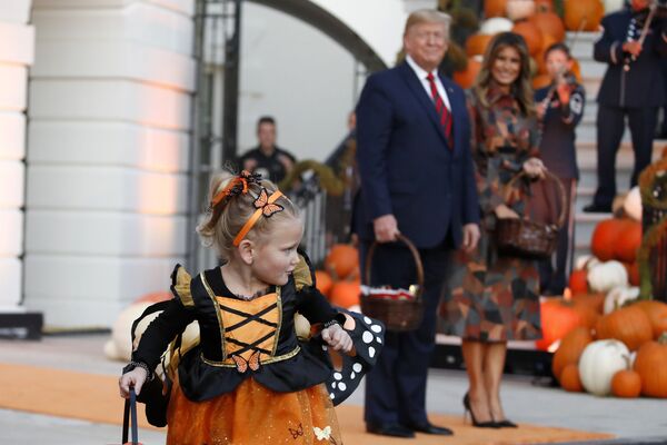 Президент США Дональм Трамп с женой во время раздачи сладостей детям в Белом доме в честь Хеллоуина - Sputnik Moldova-România