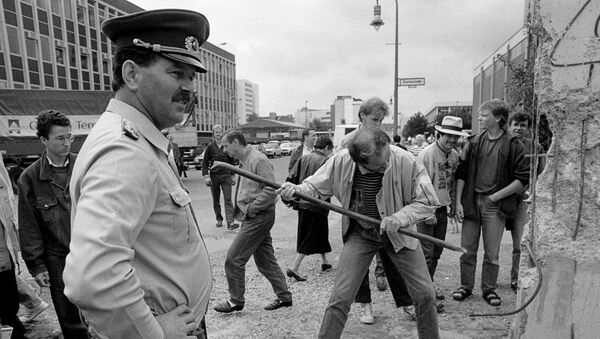 На фото сверху мужчина пытается разбить часть Берлинской стены на улице Markgrafen Strasse/Rudi-Dutschke Strasse 2 июня 1990 года, и внизу -  то же место 30 октября 2019 года, Германия - Sputnik Moldova-România