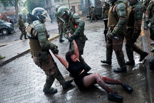 Раненая участница митинга против правительства Чили во время задержания - Sputnik Молдова