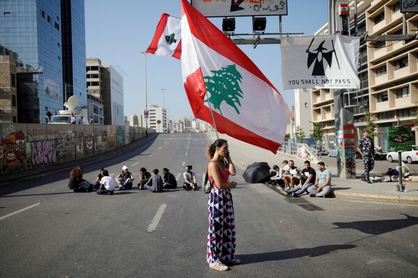 Женщина с флагом Ливана во время антиправительственных протестов в Бейруте - Sputnik Молдова