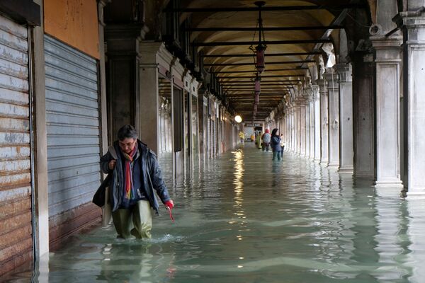 Un bărbat în piața San Marco din Veneția în timpul inundațiilor - Sputnik Moldova