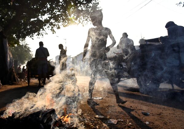 Люди проходят мимо горящего мусора в Калькутте, Индия - Sputnik Молдова
