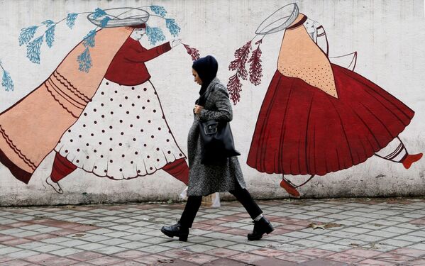 Женщина проходит мимо разрисованной стены в Тегеране, Иран - Sputnik Молдова
