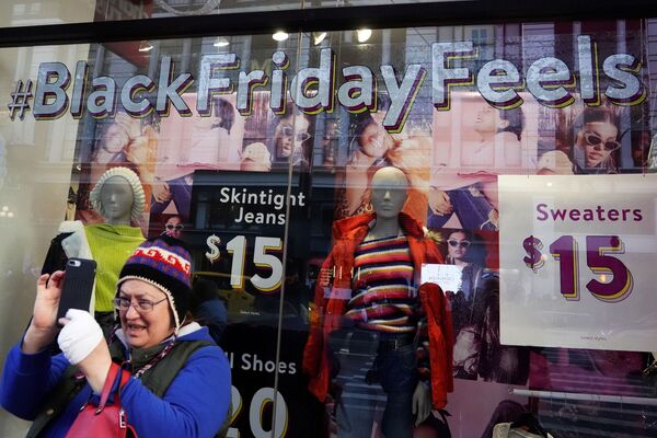 Женщина снимает селфи у магазина с рекламой Черной пятницы в Нью-Йорке, США - Sputnik Молдова