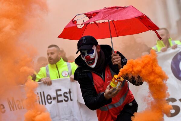 Мужчина в маске клоуна с дымовой шашкой во время протеста против пенсионной реформы в Марселе, Франция - Sputnik Молдова