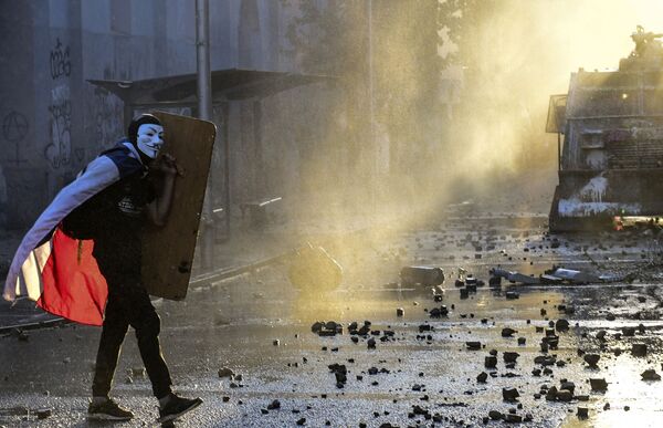 Демонстрант в маске Гая Фокса на акции протеста против правительства в Сантьяго  - Sputnik Молдова
