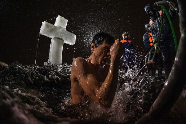 Мужчина во время традиционных купаний в праздник Крещения у храма Живоначальной Троицы в поселке Норское - Sputnik Молдова