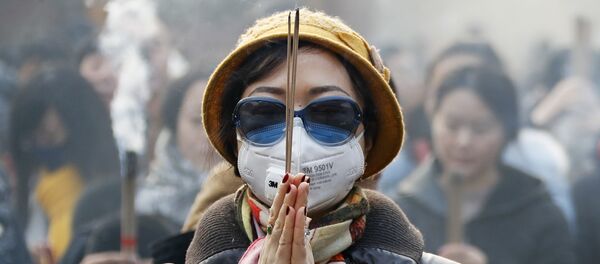 Женщина в маске и солнцезащитных очках во время молитвы в первый день Нового года в Пекине Женщина в маске и солнцезащитных очках во время молитвы в первый день Нового года в Пекине - Sputnik Молдова