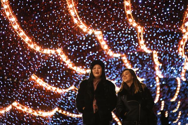 Девушки под аркой со светодиодами, установленной на Патриаршем мосту к Новому году - Sputnik Молдова
