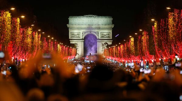 Зрители во время праздничного светового шоу перед Триумфальной аркой в Париже - Sputnik Молдова