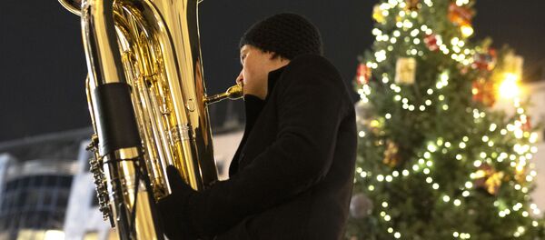 Музыкант духового оркестра Rudersdorf Music Society играет на трубе на рождественском базаре в Вене Музыкант духового оркестра Rudersdorf Music Society играет на трубе на рождественском базаре в Вене - Sputnik Молдова