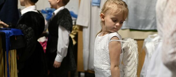 Дети во время приготовления к выступлению в честь католического Рождества в Омске  - Sputnik Молдова