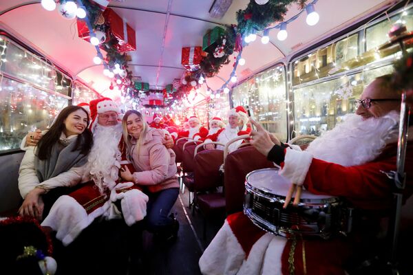 Музыканты в костюмах Санта-Клауса в автобусе в Санкт-Петербурге  - Sputnik Молдова