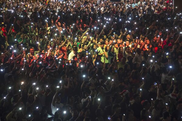 Христиане с зажженными фонарями на телефонах во время рождественской мессы в Индонезии  - Sputnik Молдова