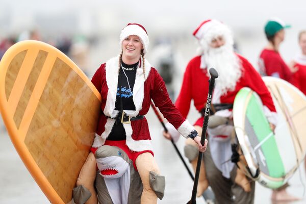 Участники ежегодного заплыва серферов в костюмах Санта-Клауса в США  - Sputnik Молдова
