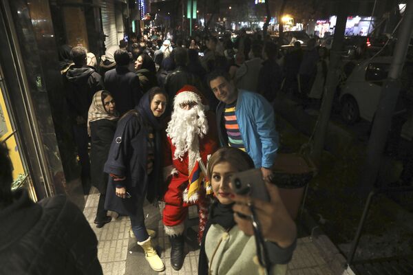 Жители во время фотографирования с Санта-Клаусом в Тегеране  - Sputnik Молдова