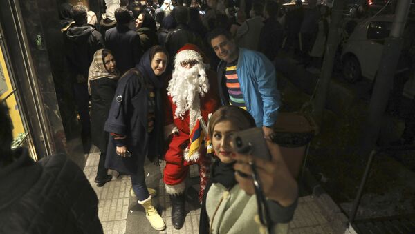 Жители во время фотографирования с Санта-Клаусом в Тегеране  - Sputnik Молдова